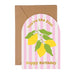A birthday greeting card with a kraft paper envelope, featuring a pink and white striped arched label with yellow lemons and green leaves, and the text 'You're the Zest Happy Birthday'. A green pen and paperclips are styled around it on a white background.
