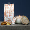 Candle with Agnes & Cat packaging and branding on a wooden surface.