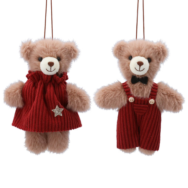 Two teddy bears wearing red outfits with scarves and overalls on a white background