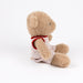 A plush teddy bear toy in light tan, wearing a red and white striped sleeveless top, sitting against a seamless white background.