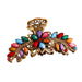 Decorative hair clip with colorful gemstones on a brown background