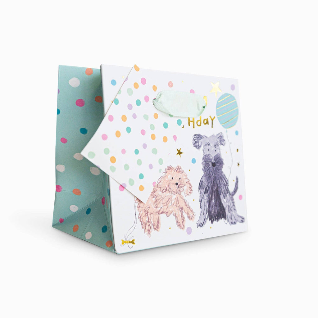 Gift bag with dog illustrations and colorful polka dots on a white background