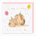A square birthday card with a white front and a pale pink envelope behind it. The card features a watercolor illustration of two brown guinea pigs wearing party hats, with gold script text reading 'Happy Birthday' and 'have a lovely day,' plus small gold and pink polka-dot balloon accents.