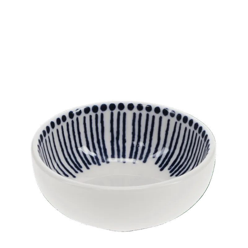 A small white ceramic bowl with a navy blue hand-painted vertical stripe pattern and a dotted border inside, shown against a solid green background.