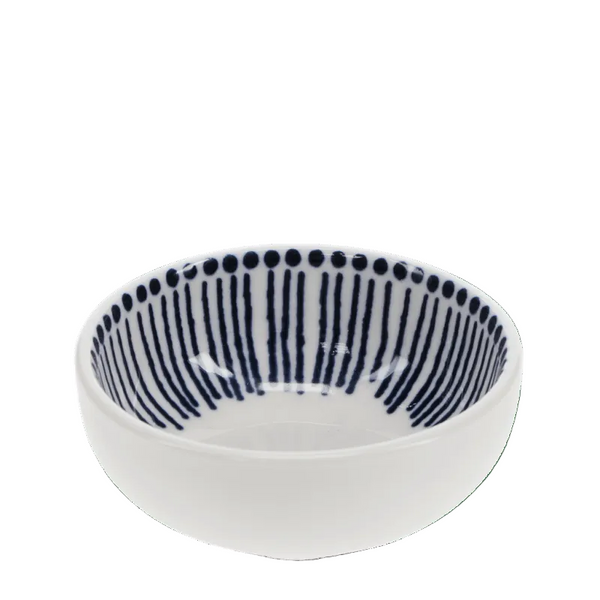A small white ceramic bowl with a navy blue hand-painted vertical stripe pattern and a dotted border inside, shown against a solid green background.