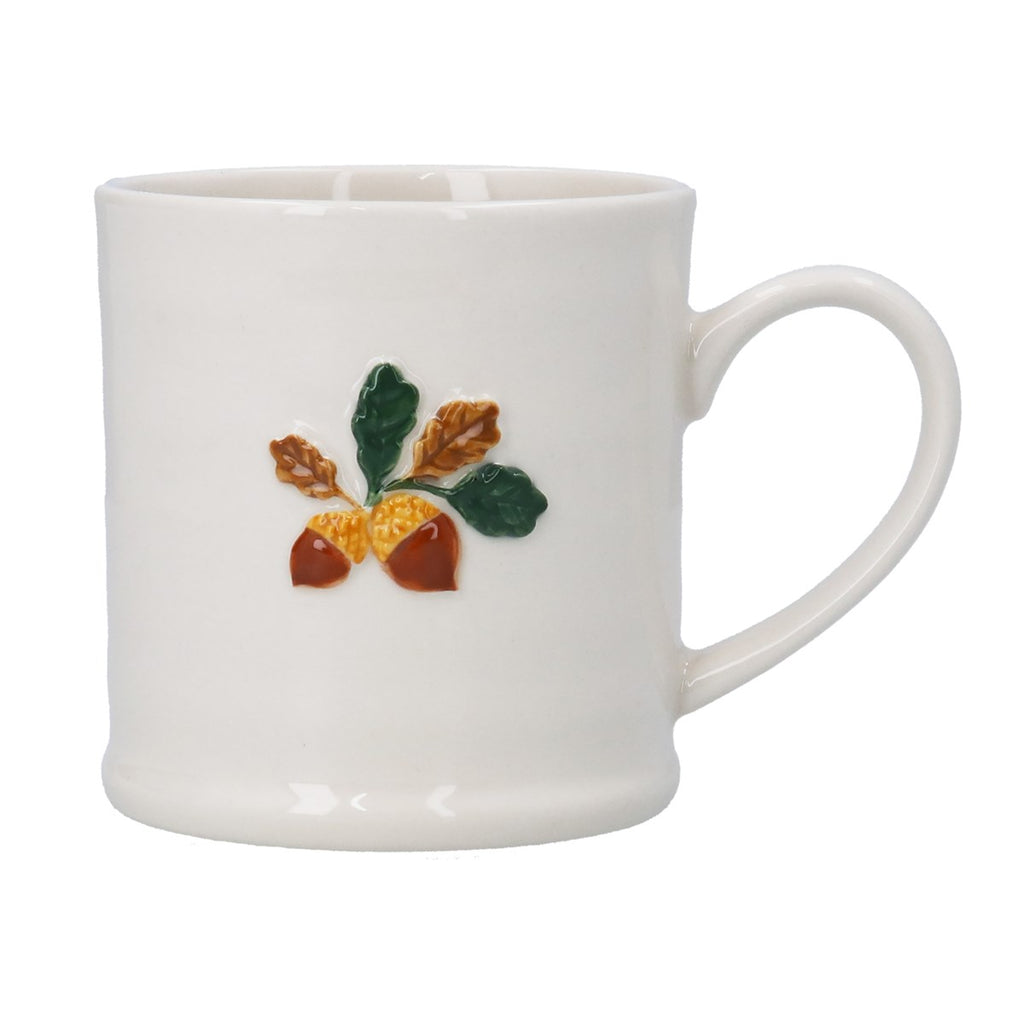 White mug with acorn and leaf design on a white background