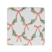 A square white fabric napkin or coaster with a repeating pattern of green pine garlands and coral-red ribbon bows, shown flat against a white background.