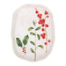 An oval ceramic serving platter with a white glaze, decorated with painted holly leaves and red berries.
