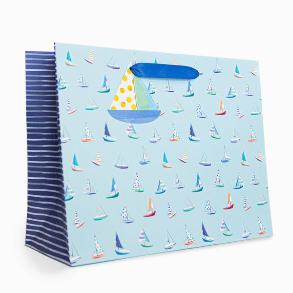 Gift bag with sailboat pattern on a light blue background
