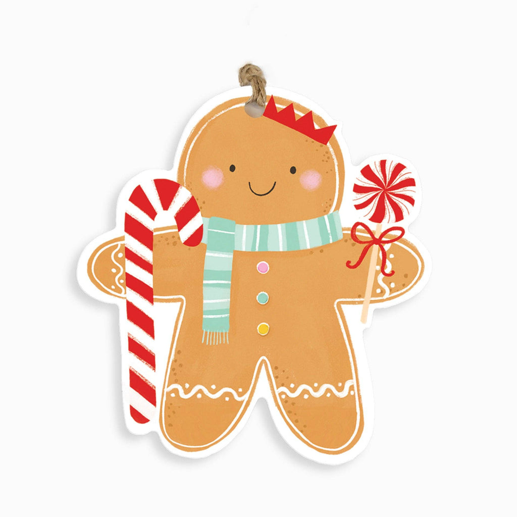 A gingerbread man Christmas ornament or wall hanging with a white border, decorated with a red-and-white striped candy cane in one hand and a red-and-white lollipop in the other. The gingerbread figure wears a mint green striped scarf, a small red hat, and colorful buttons, and hangs from a brown string on a plain white background.