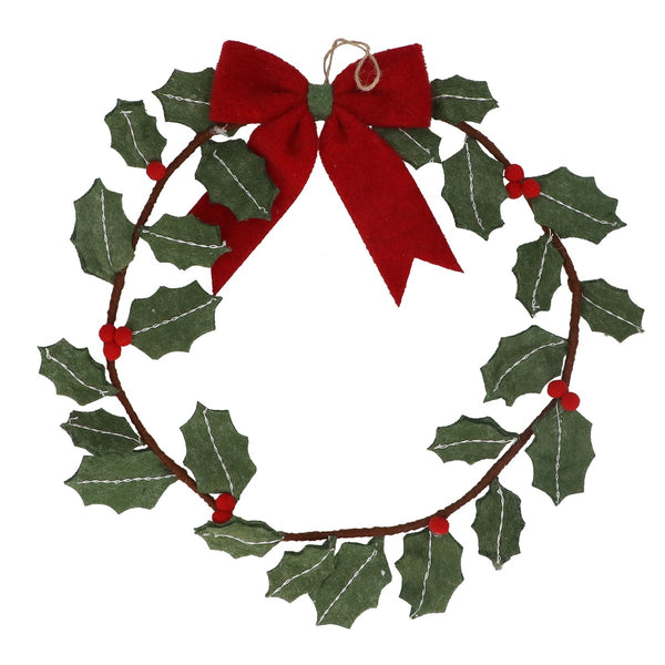 A felt Christmas wreath decoration with green holly leaves, small red berries, and a large red bow at the top, shown on a plain white background.
