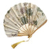 Decorative hand fan with floral pattern on a wooden surface