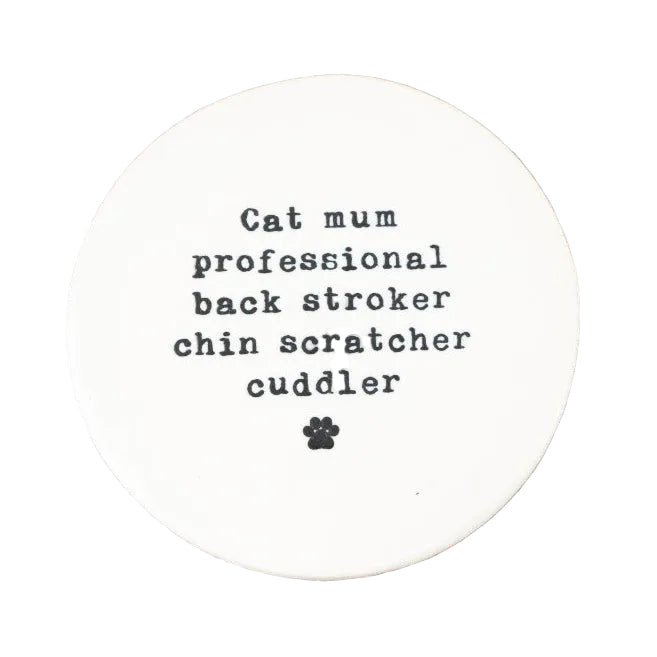 Round white coaster with text on a wooden surface