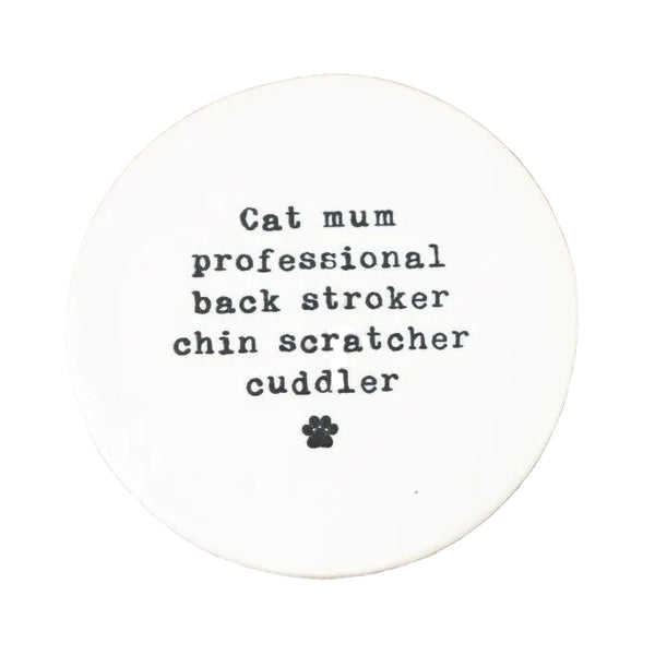 Round white coaster with text on a wooden surface