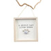 Decorative sign with 'A spoilt cat lives here' text and paw print design, hanging on a white background