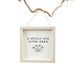 Decorative sign with 'A Spoilt Dog Lives Here' text and paw print in a wooden frame, hanging on a branch.