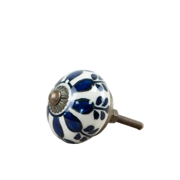 A single ceramic cabinet knob with a blue and white floral pattern and a bronze-finished metal stem, resting on a white surface.