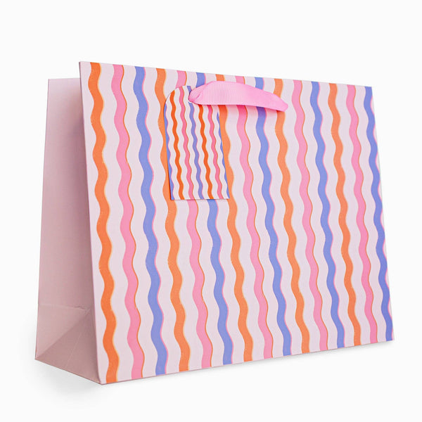 Colorful striped gift bag with a pink handle on a white background