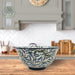 Decorative ceramic bowl with leaf pattern on a kitchen counter