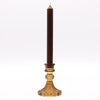 Brown candle in a decorative gold holder on a white background