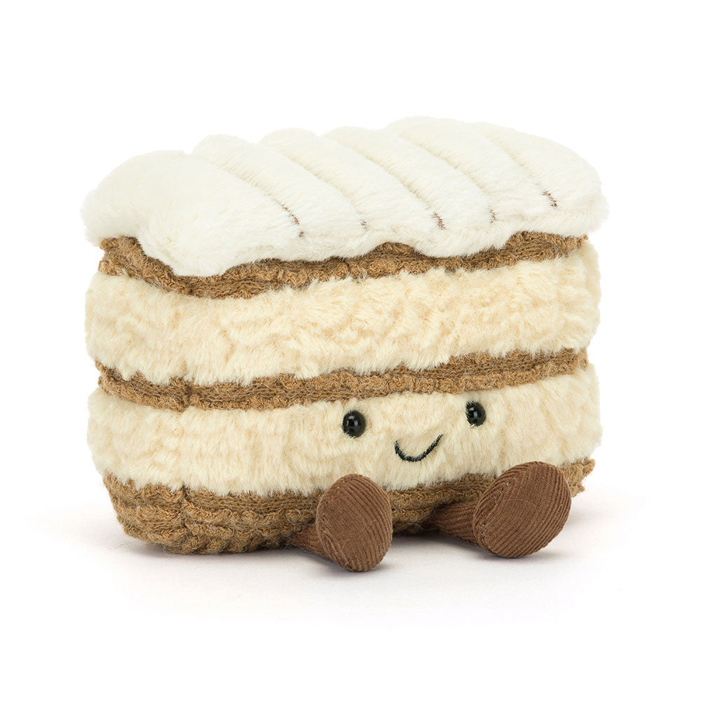 Plush toy resembling a layered dessert with white cream and brown layers on a white background