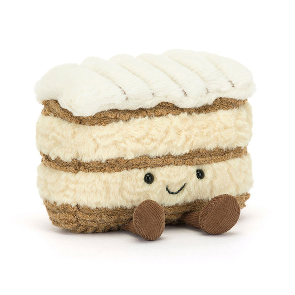 Plush toy resembling a layered dessert with white cream and brown layers on a white background