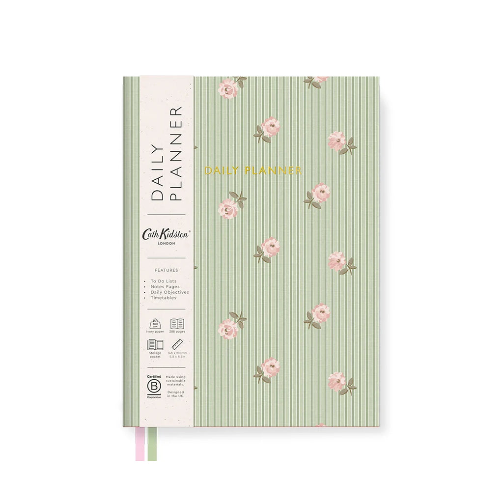 A daily planner notebook with a light green and white vertical striped cover decorated with pink floral motifs. The left spine features a cream-colored band with black text reading 'DAILY PLANNER' and 'Cute Planner London,' along with small feature icons.
