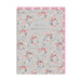 A floral greeting card with the text 'FOR THE HAPPY COUPLE' in the center, featuring a light gray background with pink, peach, white, and purple flowers. The card is shown with a pink backing board and white pom-pom trim along the top and right edges.
