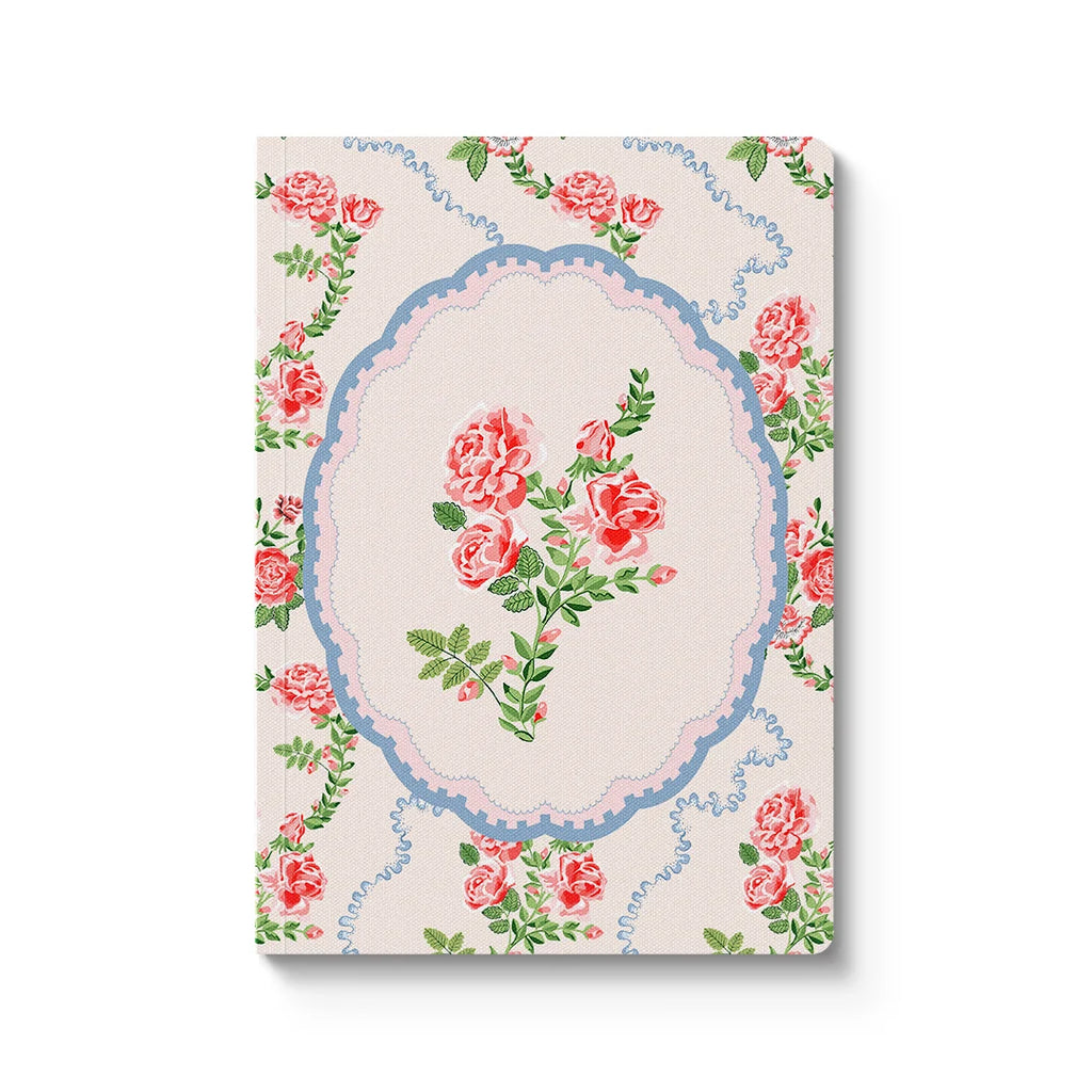 Floral patterned notebook with pink roses and green leaves on a white background