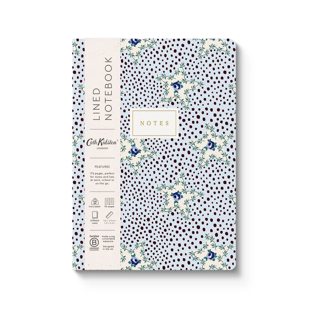 A lined notebook with a white cover decorated with dark brown polka dots and delicate blue floral illustrations. The left side features a cream-colored paper band with the text 'LINED NOTEBOOK' and 'Cork Kitten' branding.