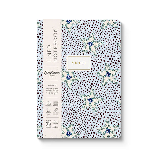 A lined notebook with a white cover decorated with dark brown polka dots and delicate blue floral illustrations. The left side features a cream-colored paper band with the text 'LINED NOTEBOOK' and 'Cork Kitten' branding.