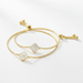 Gold bracelet with clover-shaped charms on a white background