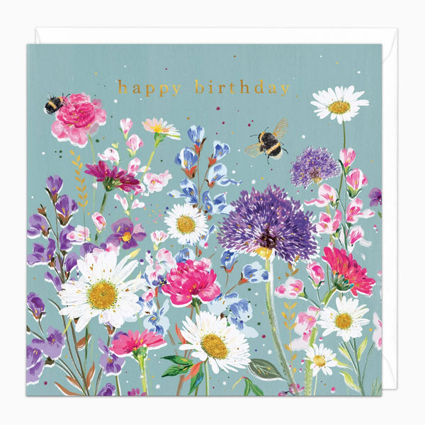 Greeting card with colorful floral design and 'happy birthday' text on a light blue background.
