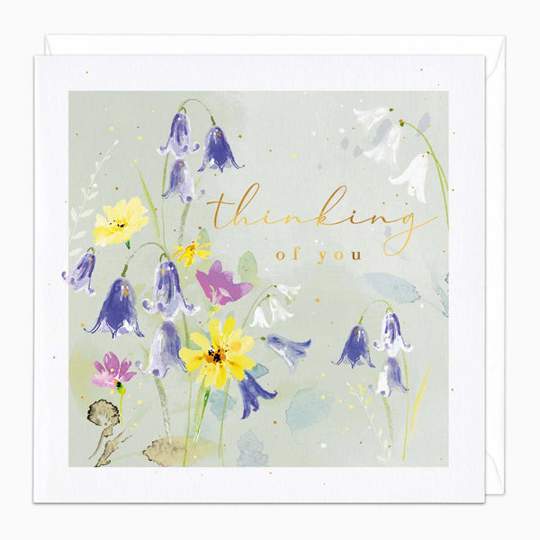 Greeting card with floral design and 'thinking of you' text on a light green background