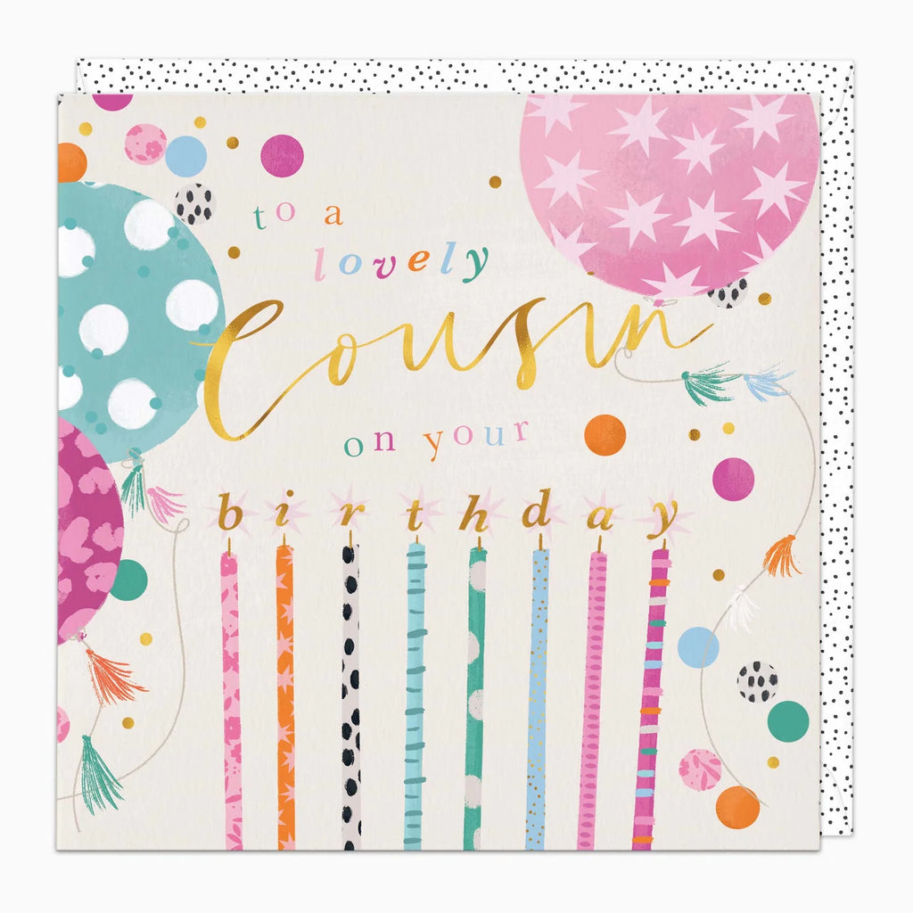 A square birthday card with a white background and colorful balloon and candle illustrations. The text reads 'to a lovely cousin on your birthday' in playful multicolor lettering, with pink, teal, orange, and gold accents.