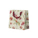 Floral-patterned paper bag with red handles on a white background