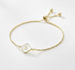 Gold bracelet with a letter 'B' charm on a white background
