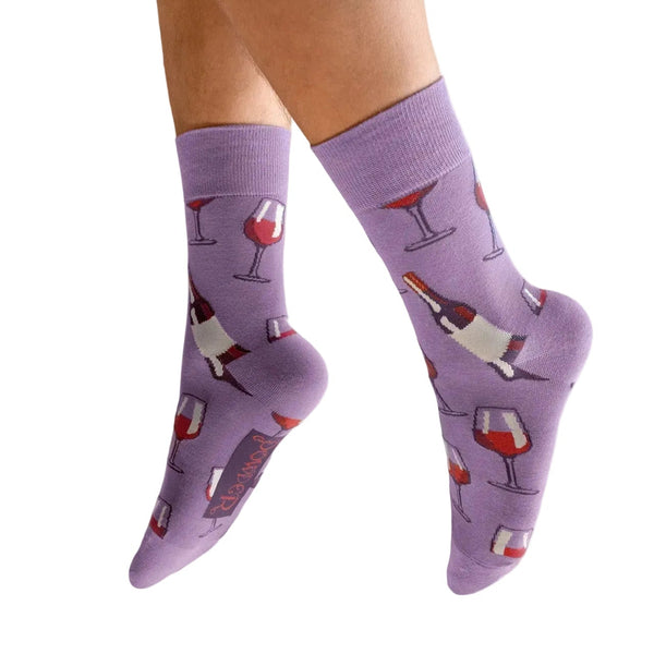 Purple socks with drink-themed design worn by a person on a white background