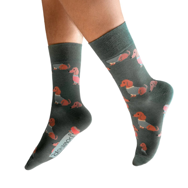 Dark gray socks with red dog pattern worn by a person on a white background