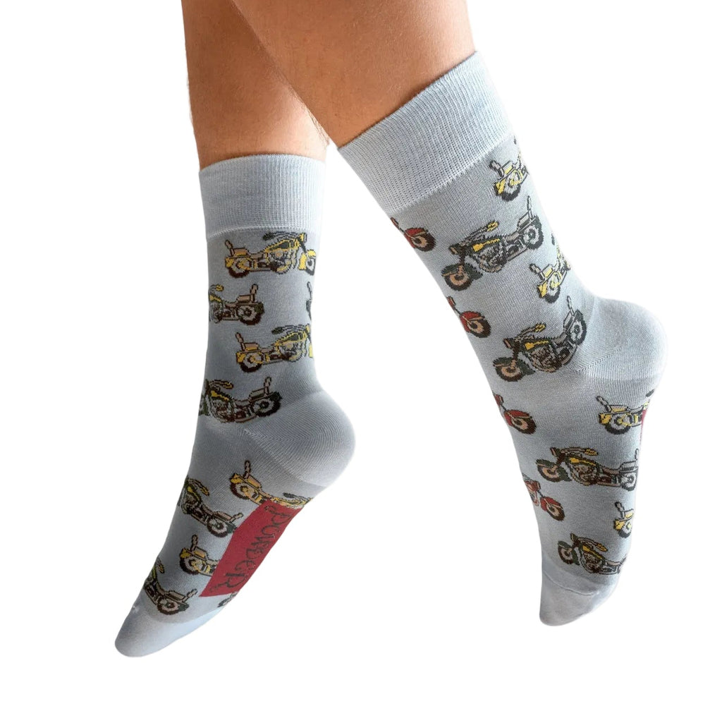 Gray socks with motorcycle pattern worn by a person on a white background