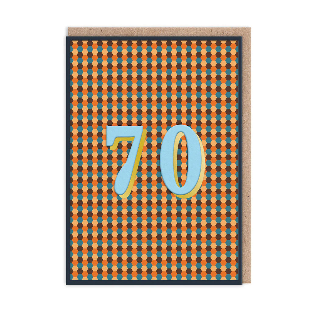 A square greeting card with a repeating orange and blue geometric pattern, featuring large light blue numbers '70' outlined in yellow. A kraft paper envelope is placed behind the card on a white background.