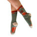 Green socks with red and beige accents worn by a person on a white background