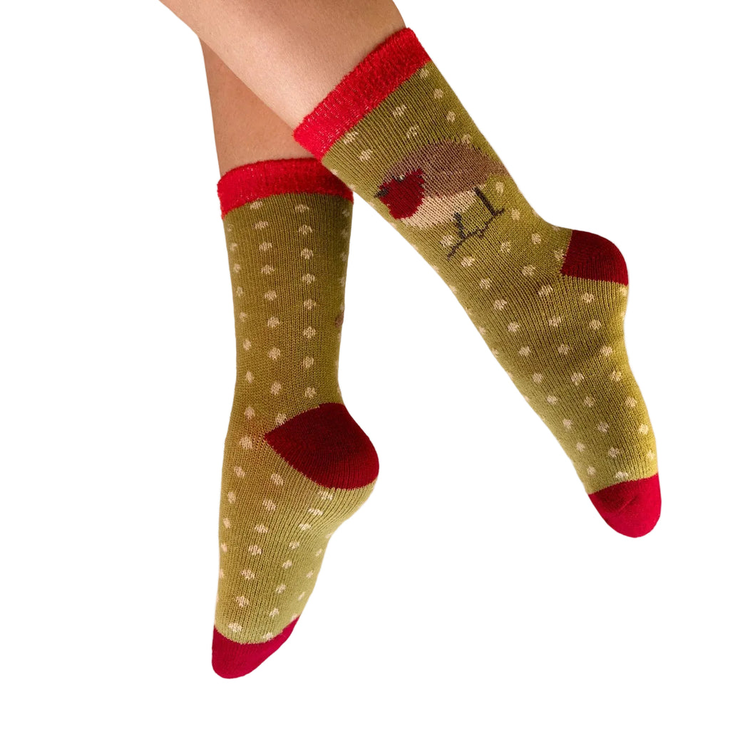 Green socks with red accents worn by a person on a white background