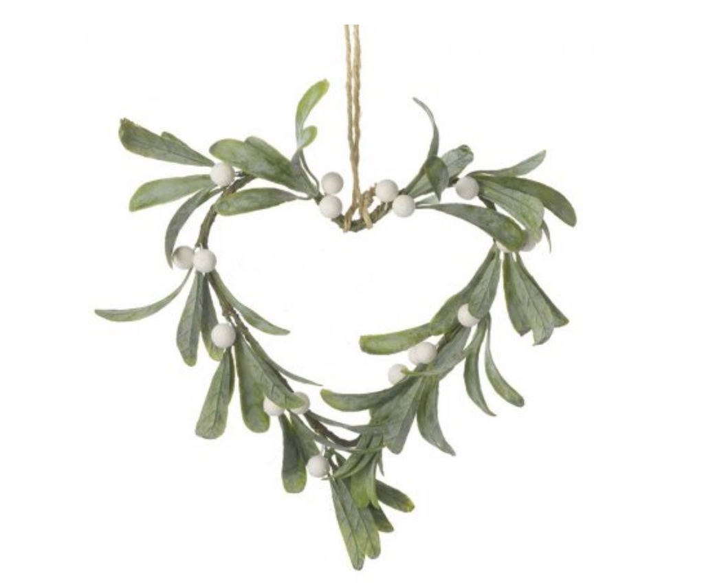 Heart-shaped wreath made of green leaves and small white berries hanging on a white background