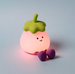  Night Light Toy resembling an eggplant with a smiling face on a grey background.