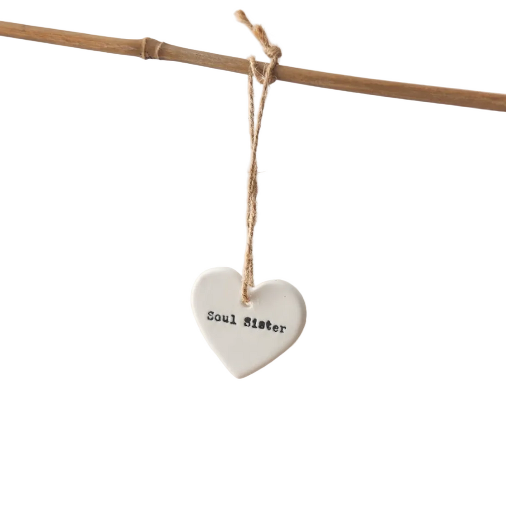 Heart-shaped ceramic tag with 'Soul Sister' text hanging on a branch