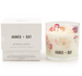Botanical candle with floral design and 'Agnes + Cat' branding next to its packaging on a white background.