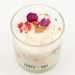 Candle with dried flowers in a glass container on a white background, branded 'Agnes + Cat'.