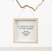 Decorative sign with 'A Spoilt Dog Lives Here' text and paw print in a wooden frame, hanging on a branch.