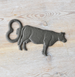 Cast iron cow bottle opener on a wooden surface